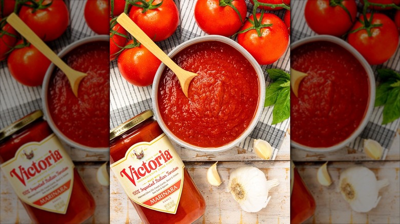 jar of Victoria sauce with pan of marinara and fresh tomatoes