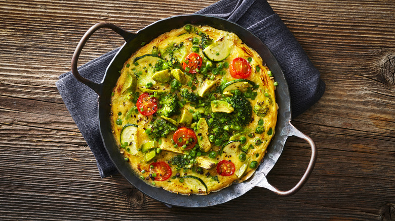 frittata baked in skillet with tomatoes and broccoli