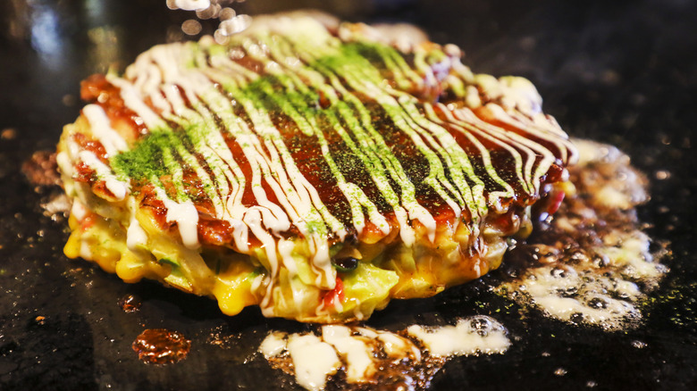 Okonomiyaki cooking on a griddle