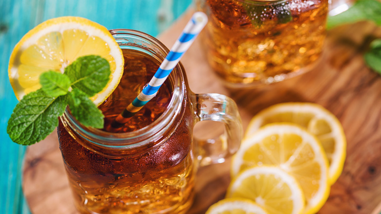 Sweet iced tea served with herbs and lemon slices