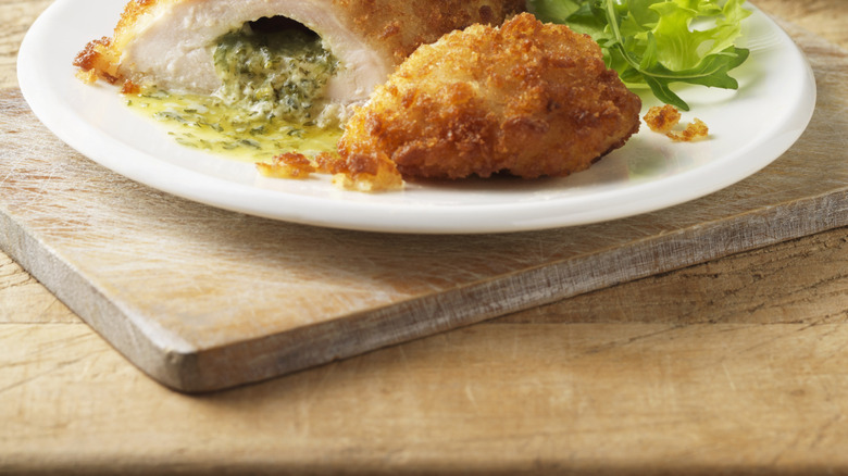 Plate of stuffed chicken Kiev with salad