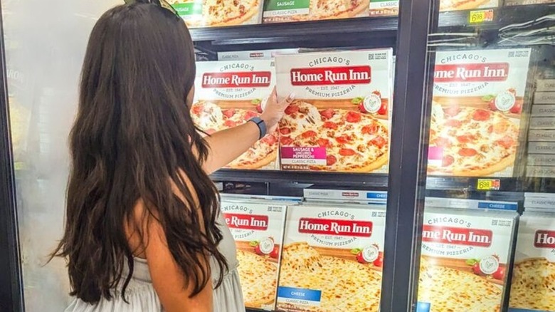 Person picks up Home Run Inn pizza off the shelf