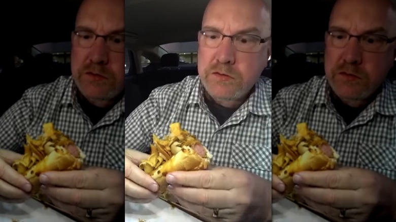 Person eating Buc-ee's chili hot dog