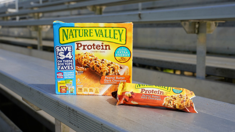 Nature Valley Protein Chewy Bars box on sunny stadium bleachers