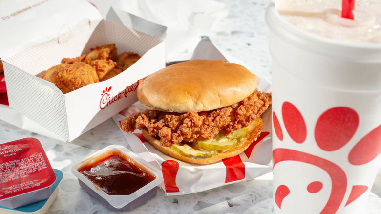 A Chick-fil-A sandwich surrounded by other Chick-fil-A products.