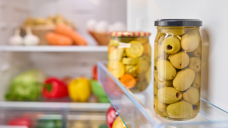 A jar of olives inside a fridge door