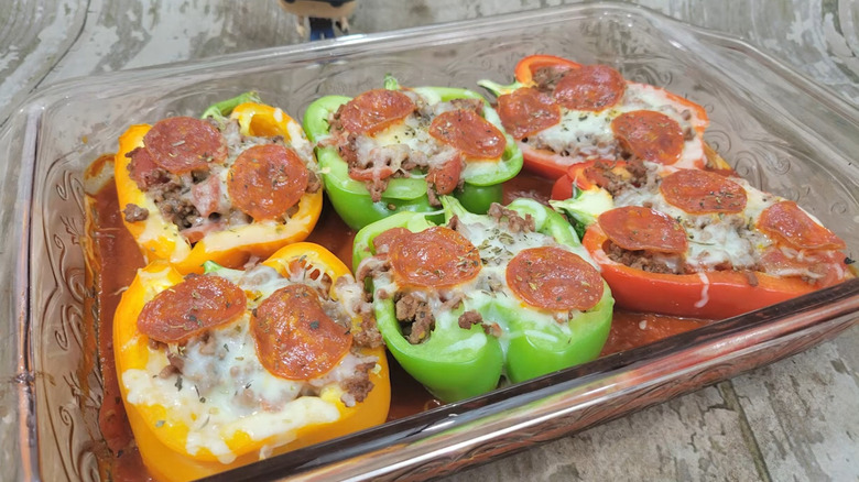 Dish of cooked peppers stuffed with pizza toppings