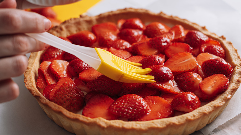 Brushing warm jelly over a fruit tart