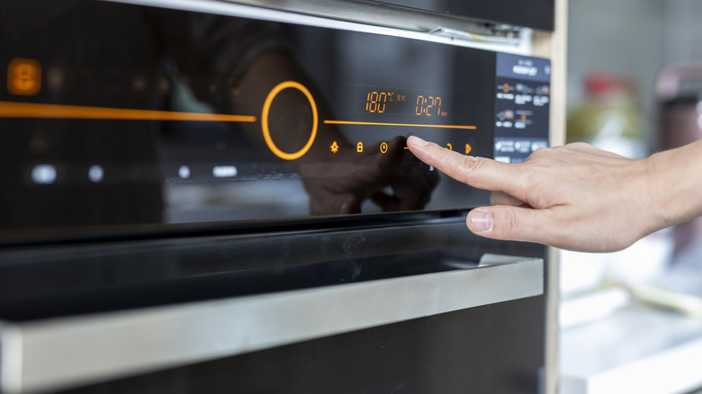 A person setting their oven timer