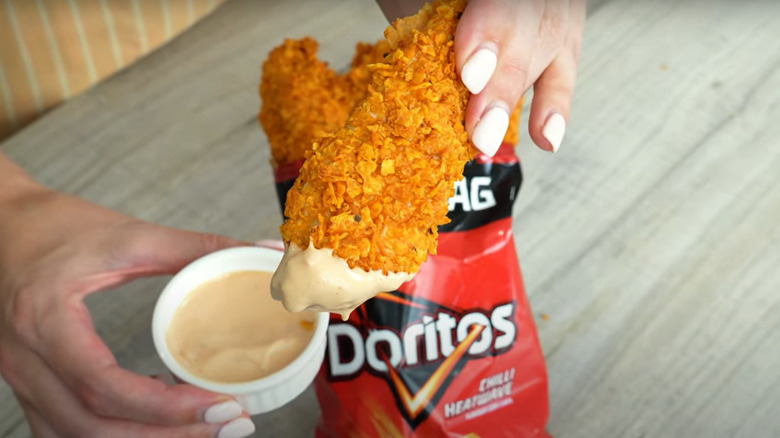 A bag of Nacho Cheese Doritos with a chicken tender