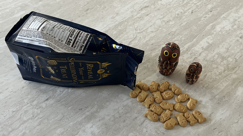 a bag of Goldfish Butterbeer Flavored Grahams spilled with two owls looking at it