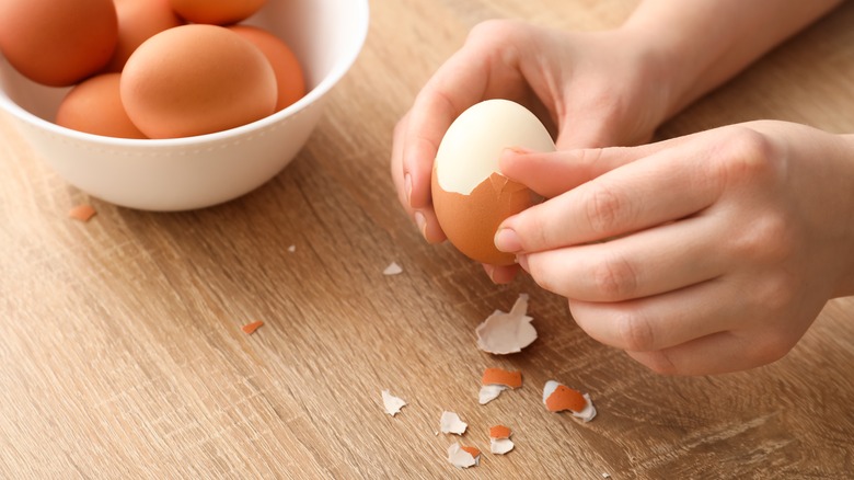 Peeling boiled eggs with shell fragments around