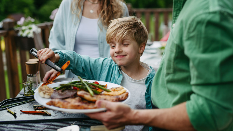 Family together in the backyard enjoying food together