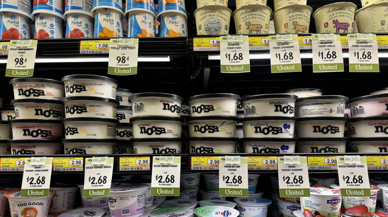 Shelves of yogurt at a grocery store with sales tags beneath them