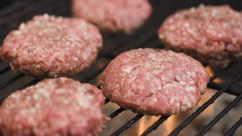 Raw ground beef burgers cooking