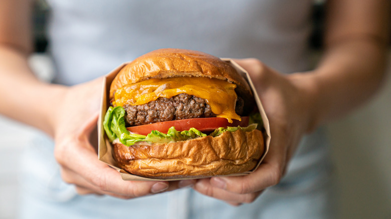 Person holds beef burger