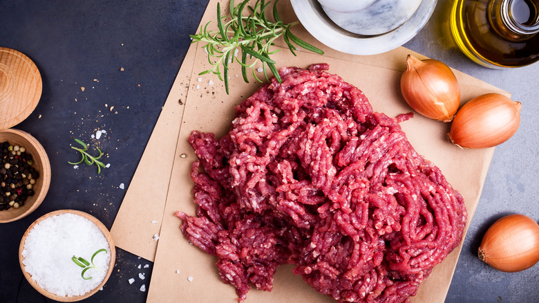 Ground beef on paper with onions and rosemary