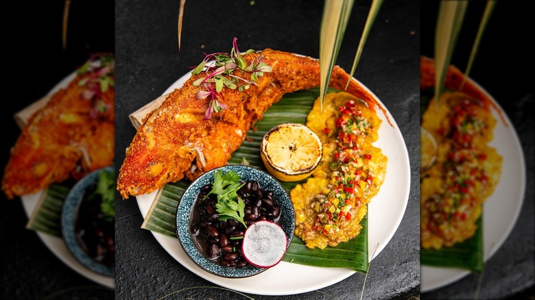 Fried fish served with black beans and tostones