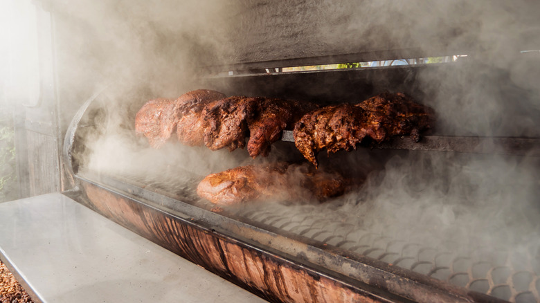 Meats being slow-cooked in smoker