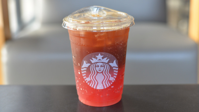 A pink soda drink in a Starbucks plastic cup