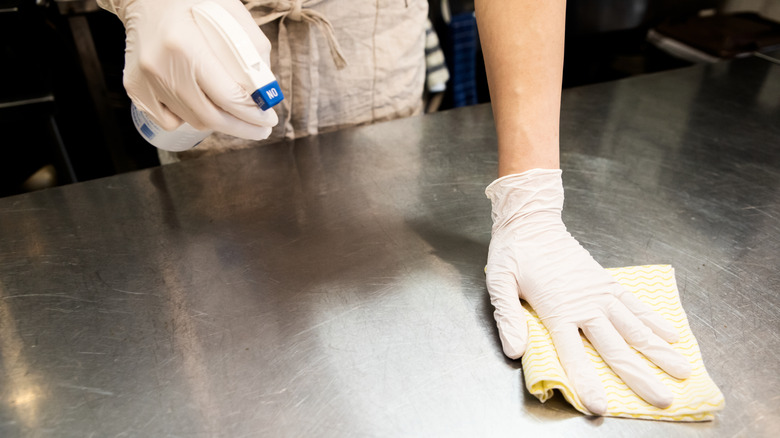 worker cleaning a restaurant kitchen surface