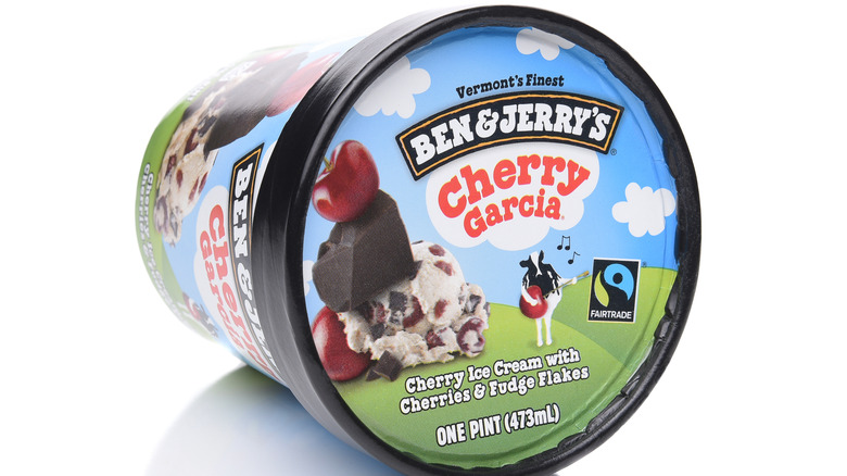 Pint of Cherry Garcia ice cream sitting on its side in front of a white background