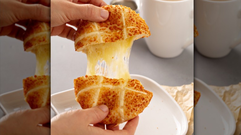 bun with melted cheese being pulled