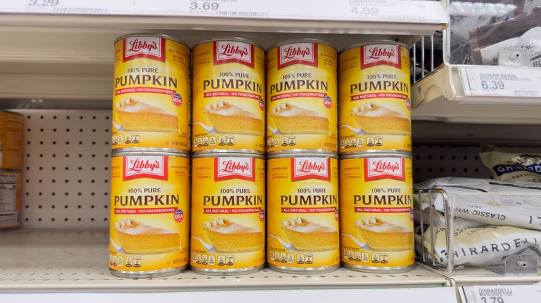 100% pure pumpkin cans stacked on top of each other in supermarket