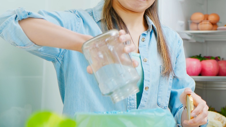 woman pours stinky food into garbage