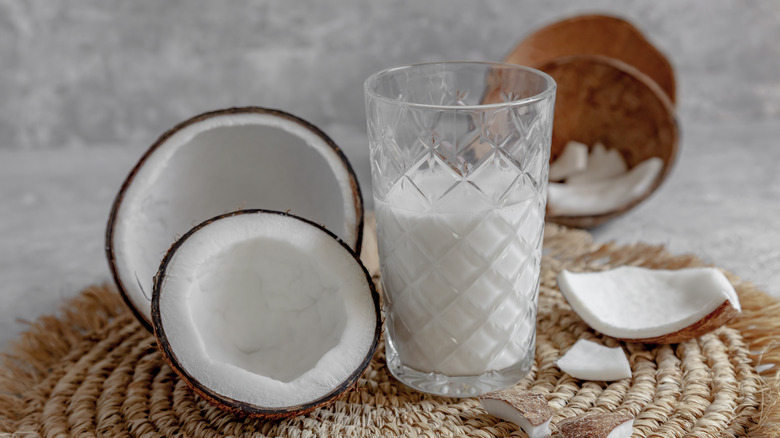 a glass of coconut milk amidst coconuts