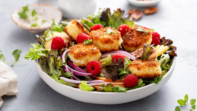 Salad with fried goat cheese, red onion, raspberries