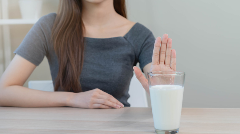 woman pushing away glass of milk