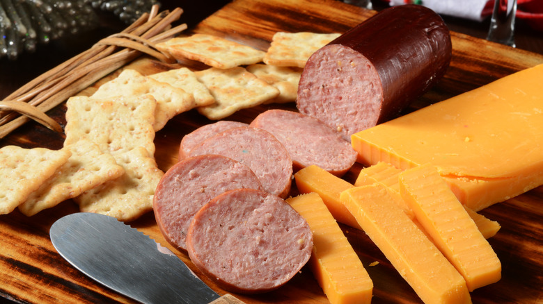 a charcuterie board with cheeses and summer sausage