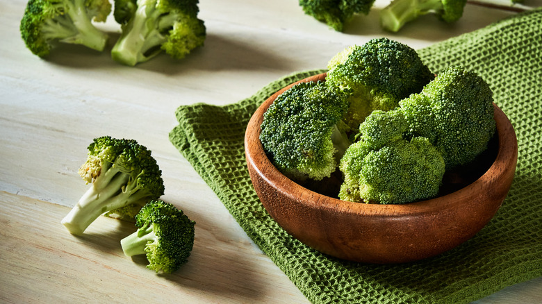 Fresh broccoli florets in a wooden bowl