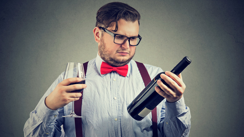 Person inspecting a wine bottle