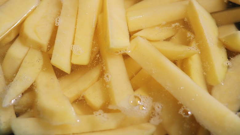 Potatoes cut for fries soaking in water