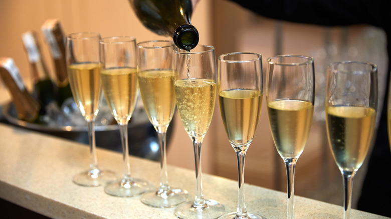 A server pouring champagne into glasses