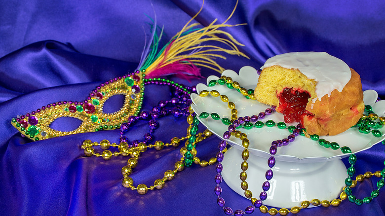 Jelly donut on white plate decorated like Mardi Gras