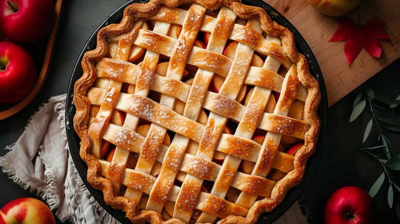 A whole apple pie with lattice crust on top, crisp and browned, still in the pie dish.