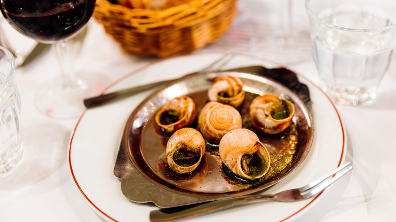 Escargot served with wine and bread.