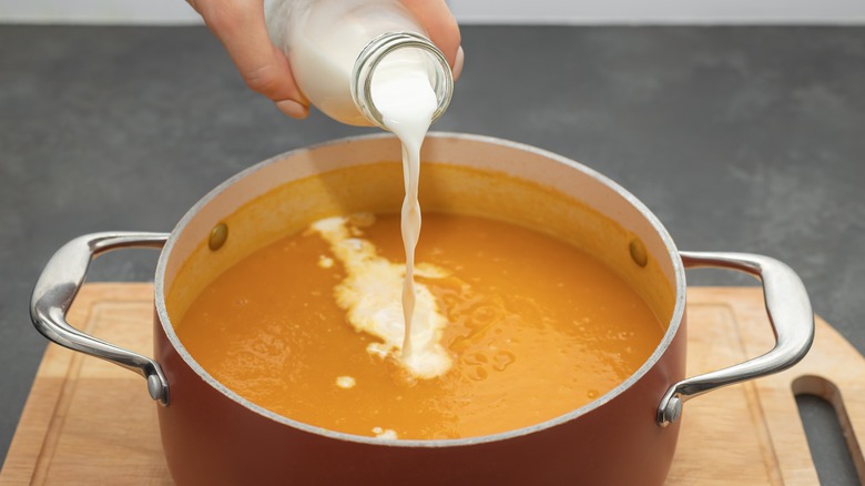 Pouring cream into pumpkin soup