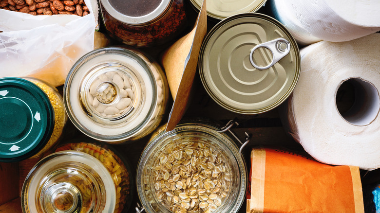 A close up of non-perishable food, canned goods, and toilet paper