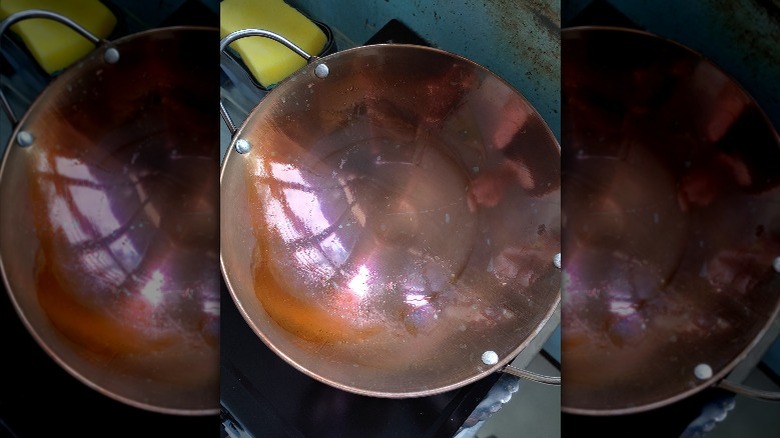 A wok being seasoned on the stove