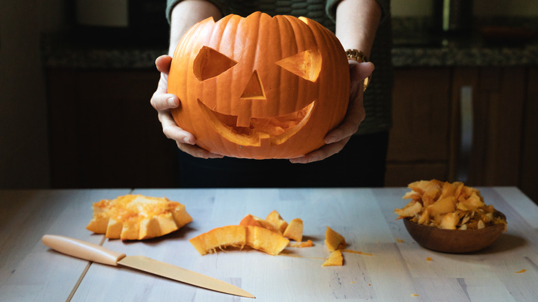 person holding jack-o'-lantern