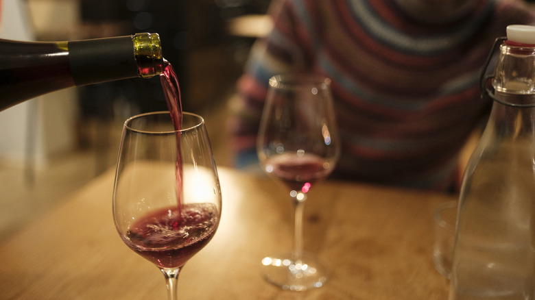 Man holds wine glass at the stem