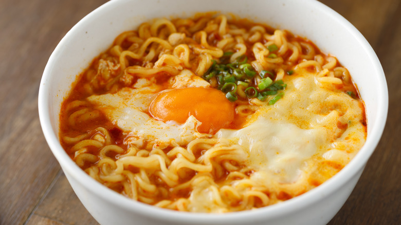 Spicy ramen in a bowl topped with cheese and an egg