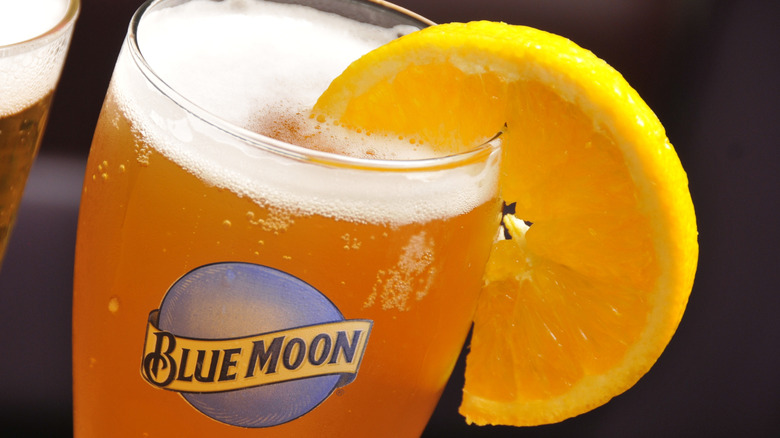 A glass of Blue Moon beer garnished with an orange slice