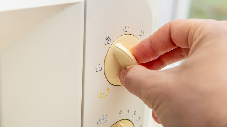 hand setting microwave to defrost mode