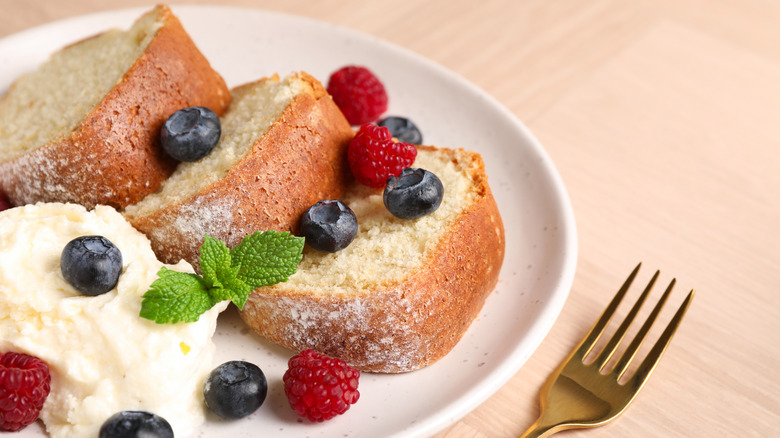 Slices of cake on a plate with berries and ice cream