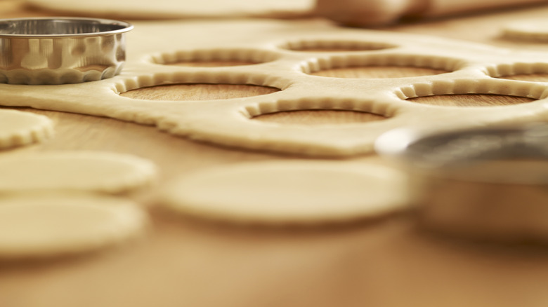 A rolled sheet of cookie dough with shapes cut into the dough